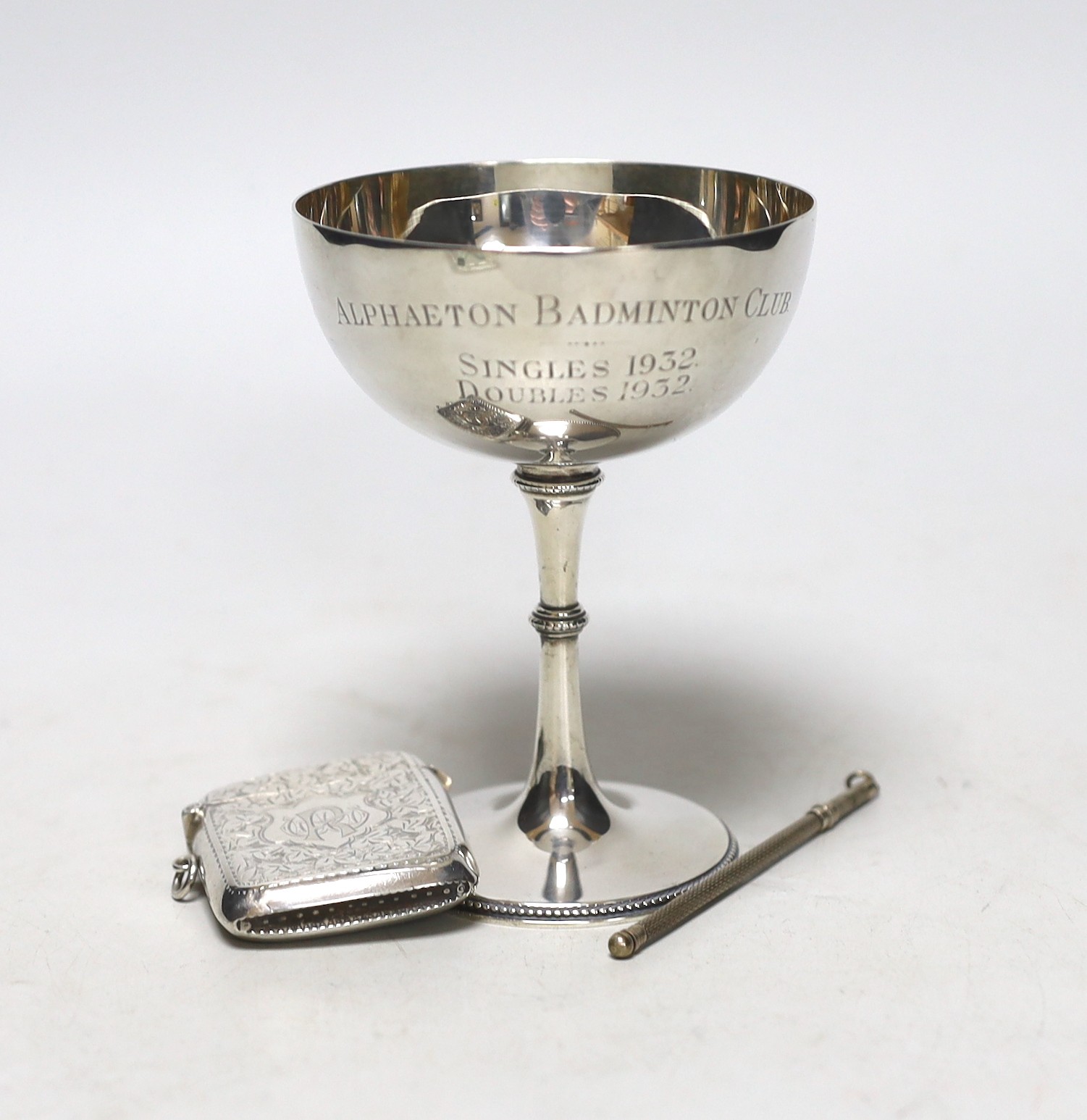 A George V silver Champagne coupe, Birmingham, 1923, 11.4cm with engraved inscription, a silver vesta case and a boxed swizzle stick.
